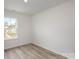 Simple bedroom with large window and wood flooring at 3008 Sadler Woods Ln, Charlotte, NC 28214