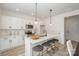 Modern kitchen with white cabinets, island with seating, and stainless steel appliances at 3008 Sadler Woods Ln, Charlotte, NC 28214