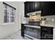 Modern kitchen features black cabinetry, stainless steel appliances, and gray tile backsplash at 301 W 10Th St # 205, Charlotte, NC 28202