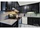 Modern kitchen with black cabinets, gray backsplash and stainless steel appliances at 301 W 10Th St # 205, Charlotte, NC 28202