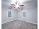 Well-lit bedroom with two windows and ceiling fan at 315 W Clairmont St, Troy, NC 27371