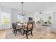 Elegant dining area with a glass table, cane chairs, modern lighting, and open layout at 3705 Lou Ann Ave, Charlotte, NC 28208