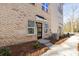 View of a townhome with brick exterior, modern black front door, and manicured landscaping at 3705 Lou Ann Ave, Charlotte, NC 28208