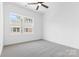 Minimalist bedroom with plush carpet, a ceiling fan, and a large window providing natural light at 3709 Lou Ann Ave, Charlotte, NC 28208