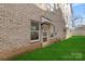 Tan three-story townhome with white garage doors and small grassy yard at 3709 Lou Ann Ave, Charlotte, NC 28208