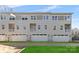 Rear view of townhome showing three garage doors and a small lawn at 3709 Lou Ann Ave, Charlotte, NC 28208