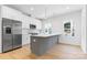 Bright kitchen with stainless steel appliances, a gray island, shaker cabinets, and views from the kitchen windows at 3709 Lou Ann Ave, Charlotte, NC 28208