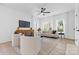 Living room with bright neutral decor, ceiling fan, large windows, and hardwood floors at 3709 Lou Ann Ave, Charlotte, NC 28208