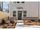 Townhouse entry with modern black door, exterior lighting, and tidy landscaping at 3713 Lou Ann Ave, Charlotte, NC 28208