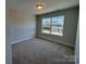 Bright bedroom featuring neutral walls, plush carpeting, and a window with neighborhood views at 5552 Stafford Rd # 28, Charlotte, NC 28215