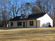 White house with black roof and trim, covered front porch, and large backyard at 6524 Athens Ln, York, SC 29745