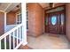 Brick front porch with decorative door and white railing at 7757 St Andrews Ln, Stanley, NC 28164