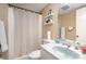 Bathroom with a shower-tub combination and vanity with decorative toiletry items at 939 Malotte Ln, Gastonia, NC 28054