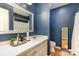 Bathroom featuring navy walls, a white vanity, and a large decorative mirror at 939 Malotte Ln, Gastonia, NC 28054