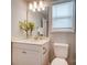 A bathroom with a single sink vanity, toilet, and window at 9831 Quercus Ln, Huntersville, NC 28078