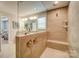 Modern bathroom featuring a glass shower with a built-in bench, dual faucet valves, and a large vanity mirror at 9831 Quercus Ln, Huntersville, NC 28078