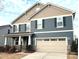 Charming two-story home featuring a two-car garage, stone accents, and tasteful blue siding at 9831 Quercus Ln, Huntersville, NC 28078