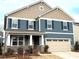 Two-story home with blue and beige siding, a two-car garage and landscaping at 9831 Quercus Ln, Huntersville, NC 28078