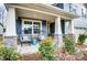 Inviting front porch with stylish outdoor seating and stone accents on the columns with well landscaped yard at 9831 Quercus Ln, Huntersville, NC 28078