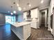 An open-concept kitchen with white cabinets, island seating, and stainless steel appliances at 9831 Quercus Ln, Huntersville, NC 28078