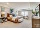 Spacious bedroom with tray ceiling, stylish furnishings, neutral tones, and ample natural light from large windows at 9831 Quercus Ln, Huntersville, NC 28078