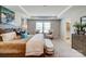 Bright main bedroom with a tray ceiling, neutral decor, ample natural light, and a glimpse of the en-suite bathroom at 9831 Quercus Ln, Huntersville, NC 28078