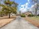 Brick house with long driveway, detached garage, and mature trees on a spacious lot at 10140 Steele Creek Rd, Charlotte, NC 28273