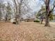 Large lot covered in fallen leaves, with a house and garage visible in the background at 10140 Steele Creek Rd, Charlotte, NC 28273