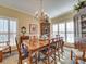 Elegant dining room with large windows, hardwood floors, and a beautiful chandelier at 125 Musketball Ct, Indian Trail, NC 28079