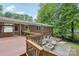 Brick home with a wooden deck, a stone patio with firepit, and green landscaping at 132 30Th Nw Ave, Hickory, NC 28601