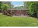 Spacious green backyard showcasing a brick home with a deck, patio, and lush trees at 132 30Th Nw Ave, Hickory, NC 28601
