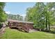Brick home with a deck and stone patio, complemented by a well-manicured lawn and mature trees at 132 30Th Nw Ave, Hickory, NC 28601