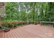 Spacious wooden deck with black railings surrounded by lush green trees, offering a serene outdoor space at 132 30Th Nw Ave, Hickory, NC 28601