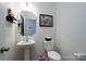 Powder room with pedestal sink, toilet, and framed artwork at 18106 Pear Hawthorne Dr, Huntersville, NC 28078