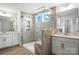 Bright bathroom featuring a glass enclosed shower, dual sink vanity, and modern finishes at 2024 Embassy Ct # 49, Charlotte, NC 28213
