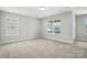 Bright bedroom featuring two windows and neutral carpet, creating a calming space at 2024 Embassy Ct # 49, Charlotte, NC 28213