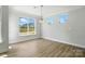 Dining area with hardwood floors, a modern chandelier, and abundant natural light from multiple windows at 2024 Embassy Ct # 49, Charlotte, NC 28213