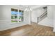 Welcoming foyer featuring wainscoting, hardwood floors, a modern chandelier, and a staircase at 2024 Embassy Ct # 49, Charlotte, NC 28213