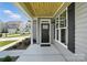 Welcoming front porch with wood ceiling and modern black front door at 2024 Embassy Ct # 49, Charlotte, NC 28213