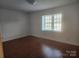 Simple bedroom with wood flooring and large window at 3508 Colony Rd # H, Charlotte, NC 28211