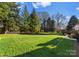 Large grassy backyard with mature trees, providing privacy at 5401 Sunningdale Dr, Charlotte, NC 28277
