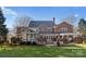 Home's back view, showcasing a deck, screened porch, and yard at 5401 Sunningdale Dr, Charlotte, NC 28277