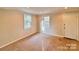 Bright bedroom with neutral walls, carpet flooring, and two windows at 6200 George Hildebran School Rd, Hickory, NC 28602