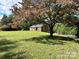 Brick ranch home with a large grassy yard, mature trees, and a swimming pool at 6200 George Hildebran School Rd, Hickory, NC 28602