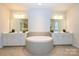 Bright bathroom featuring a soaking tub, double vanity, mirrors, and recessed lighting at 7542 Waverly Walk Ave # 7542, Charlotte, NC 28277
