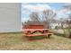 View of a red picnic table on a grass lawn, ideal for outdoor dining and entertaining guests at 8702 Wood Sorrel Ct, Matthews, NC 28105