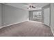 Features a large window, neutral-colored walls, neutral colored carpet, and a ceiling fan at 8702 Wood Sorrel Ct, Matthews, NC 28105
