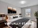 This staged primary bedroom features a large bed, wood nightstands and modern decor at 8702 Wood Sorrel Ct, Matthews, NC 28105