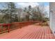 Wide wooden deck with red railings provides ample space for outdoor seating and entertainment overlooking the yard at 8702 Wood Sorrel Ct, Matthews, NC 28105