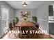 This virtually staged dining room has a wooden table and chairs, perfect for entertaining at 8702 Wood Sorrel Ct, Matthews, NC 28105